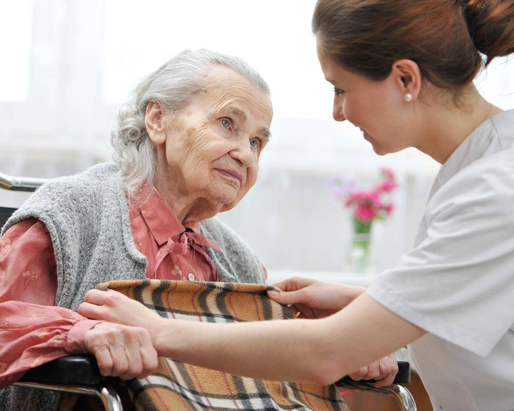 Residents being cared for by an employee, a perk among the living features offered at Carrier Mills