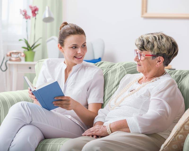 Residents reading a book, a perk among the living features offered at Carrier Mills
